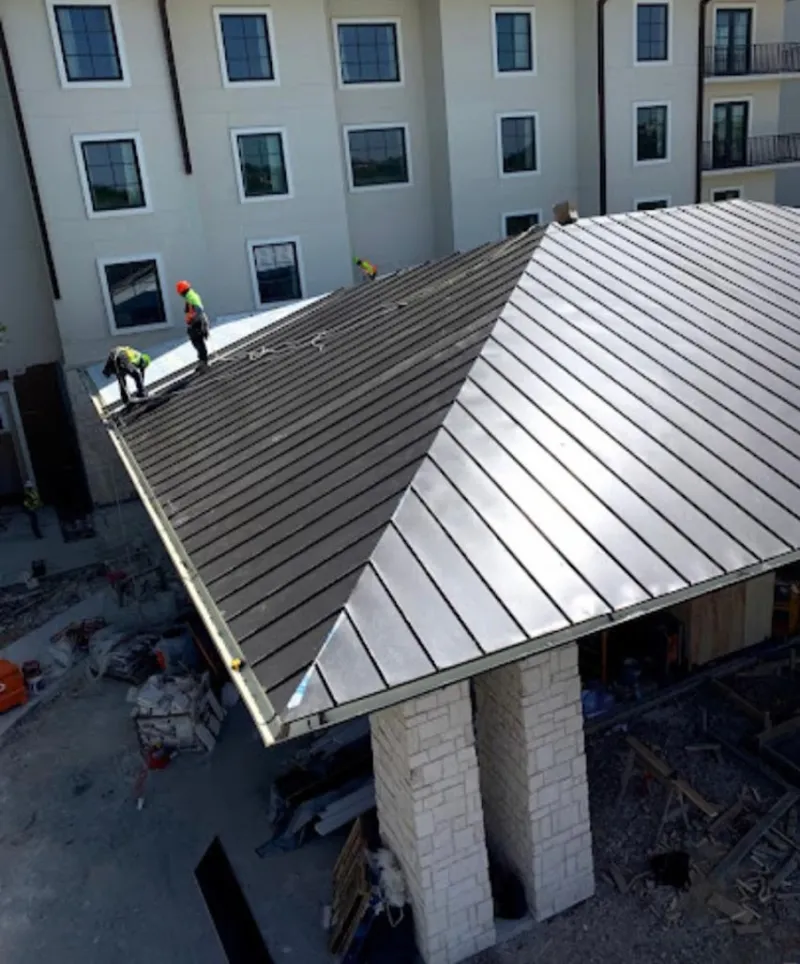 Crew installing standing seam metal roof panels on a commercial project in Blaine